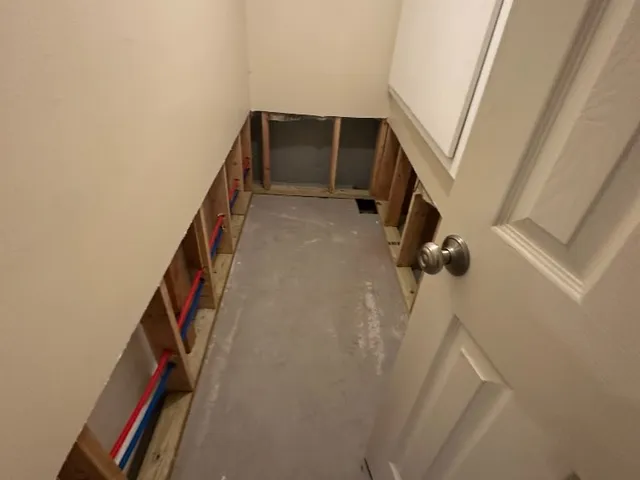 Unfinished basement bathroom during renovation with exposed framing and concrete floor