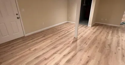 Finished basement with fresh beige walls and new light wood-look flooring