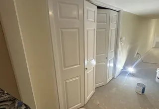 Freshly painted white six-panel closet doors and trim during an interior job