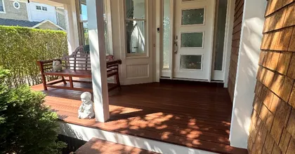Front porch with richly stained mahogany decking, white columns and cedar shingles