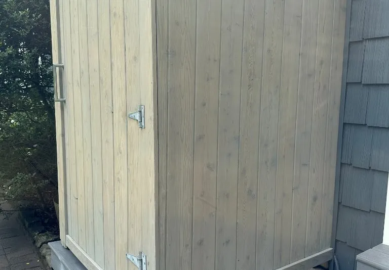 Outdoor shower enclosure after a fresh gray weatherproof stain