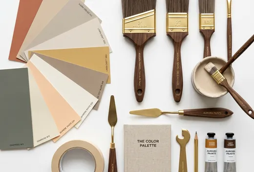 Flat-lay of paint brushes, color sample cards and tools on a white surface